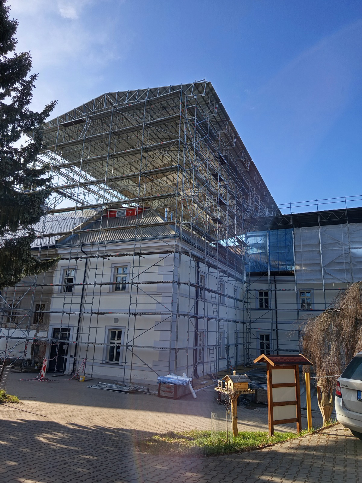 Rekonstrukce historického objektu s rozsáhlým lešením během stavebních prací na obnově budovy.
