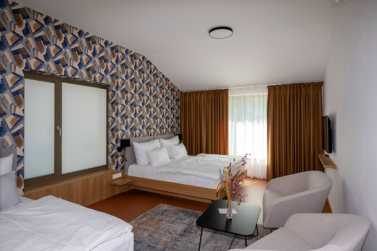 Butikový pokoj hotelu Bronzo s výraznou tapetou a moderním interiérem