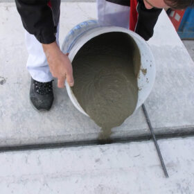 Lití expanzivní betonové směsi do spáry mezi betonovými prvky.