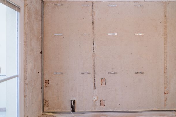 Kotvení stavěcích třmenů - Podle umístění R-CD profilů vyměříme polohu stavěcích třmenů. Rozteč svislých R-CD profilů je 625 (600) mm, vertikální rozteč 1 250 mm. Poslední horní třmen umisťujeme tak, aby horní přesah profilu byl max. 250 mm. Kotvíme plastovými natloukacími hmoždinkami.
