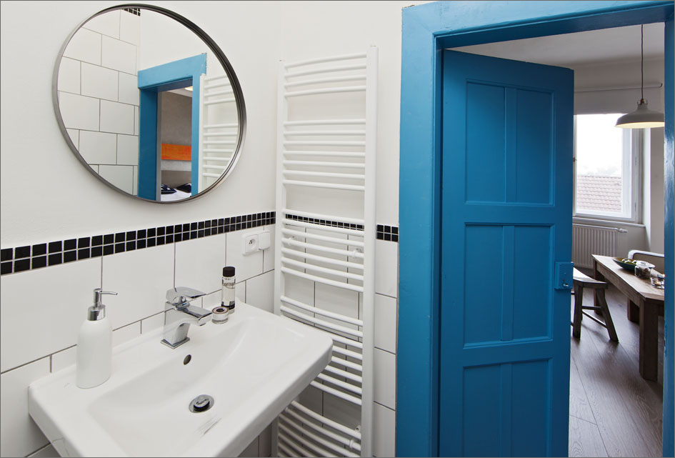 S dveřmi do koupelny se jasně modrá barva dostává i do ní.