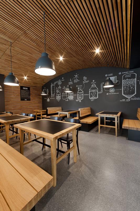 Design interiéru je tedy založen na parafrázování pivovarnických sklepů v podobě kleneb vytvořených z dřevěných kulatin.