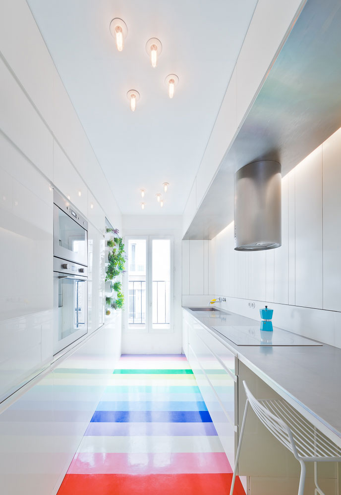 Hladké bílé plochy stěn i vybavení, které malý prostor prosvětlují a zvětšují, jsou použity také v kuchyni.
