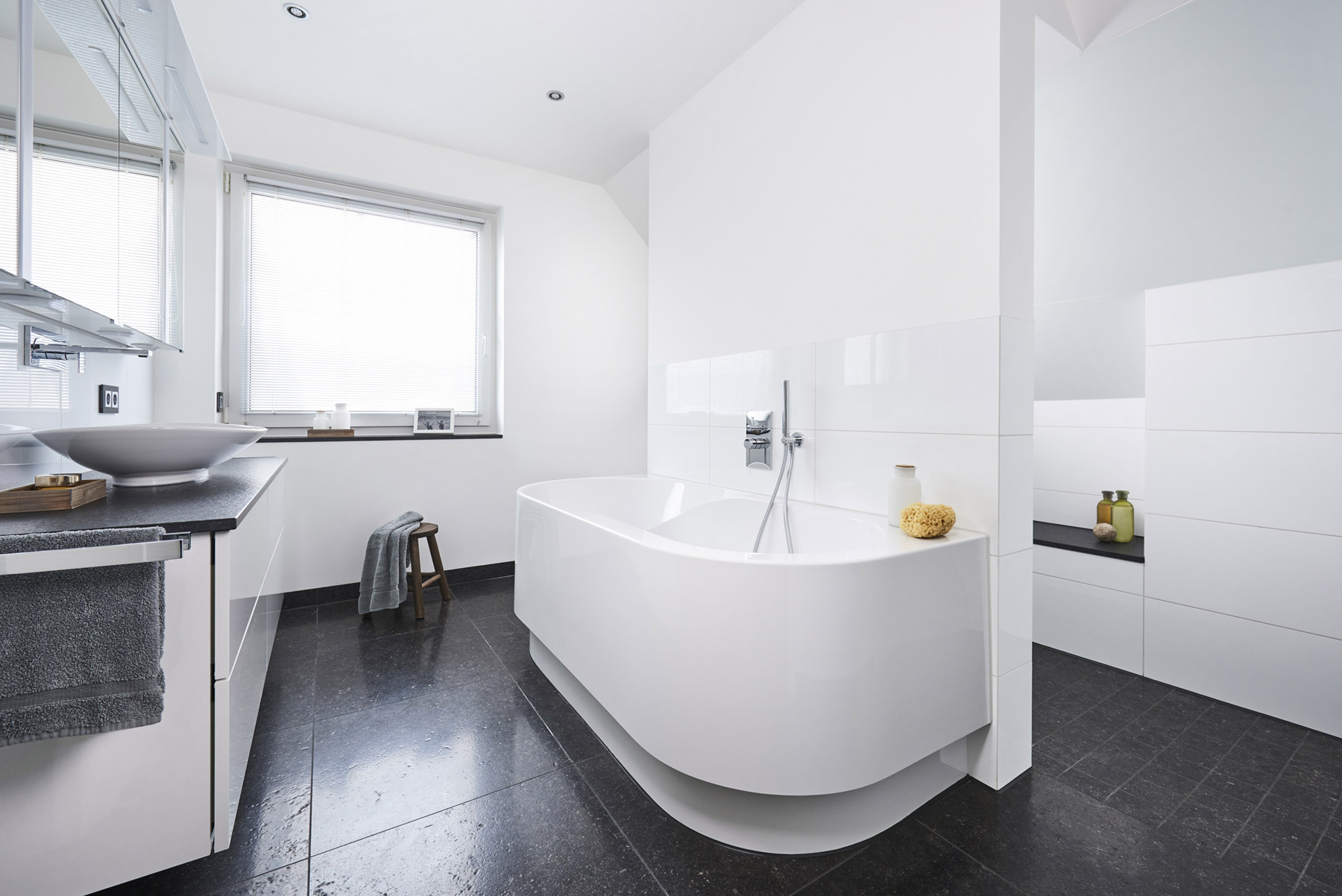 Přesvědčivá přeměna: Oddělující předstěna architektonicky stylově rozděluje místnost a slouží na jedné straně k instalaci vany, na druhé straně sprchy a v zadní oblasti WC. (Foto: Viega)
