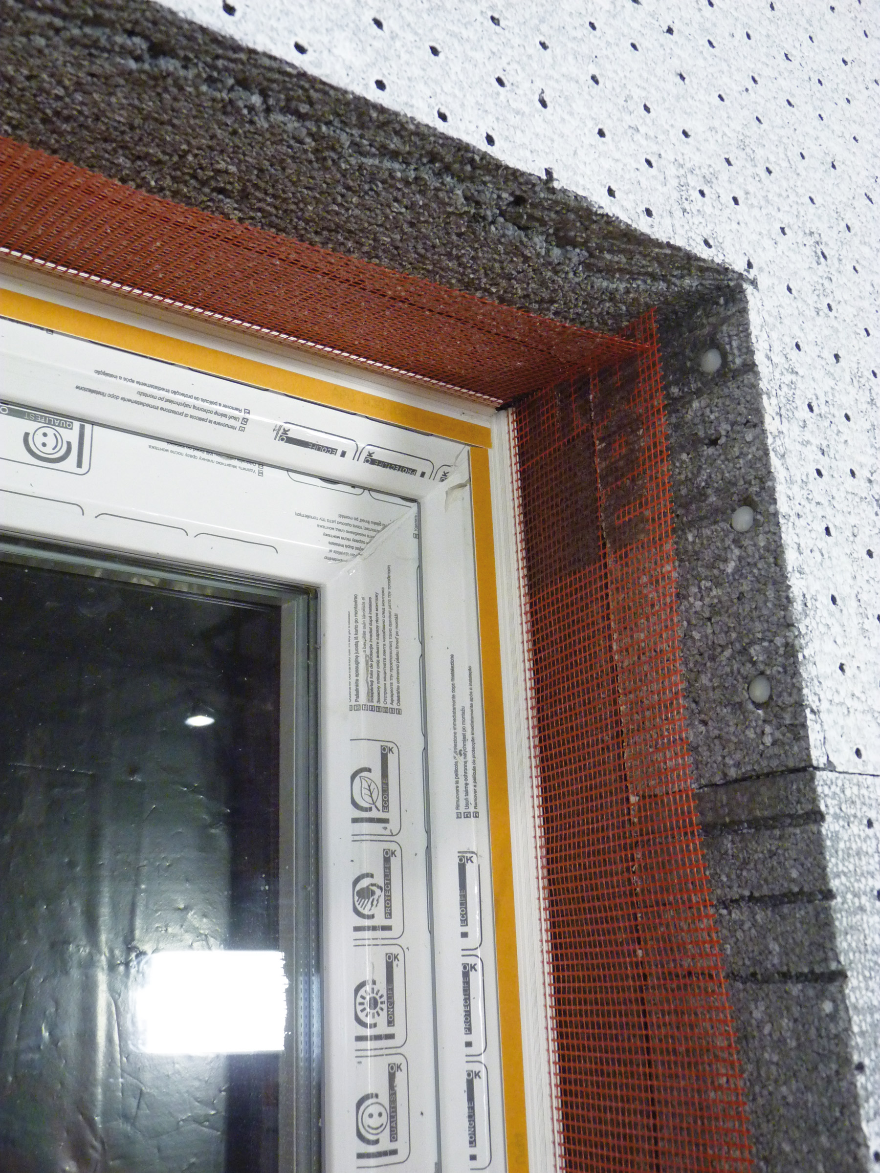 Osazené okenní připojovací profily ve špaletě a nadpraží okna.
