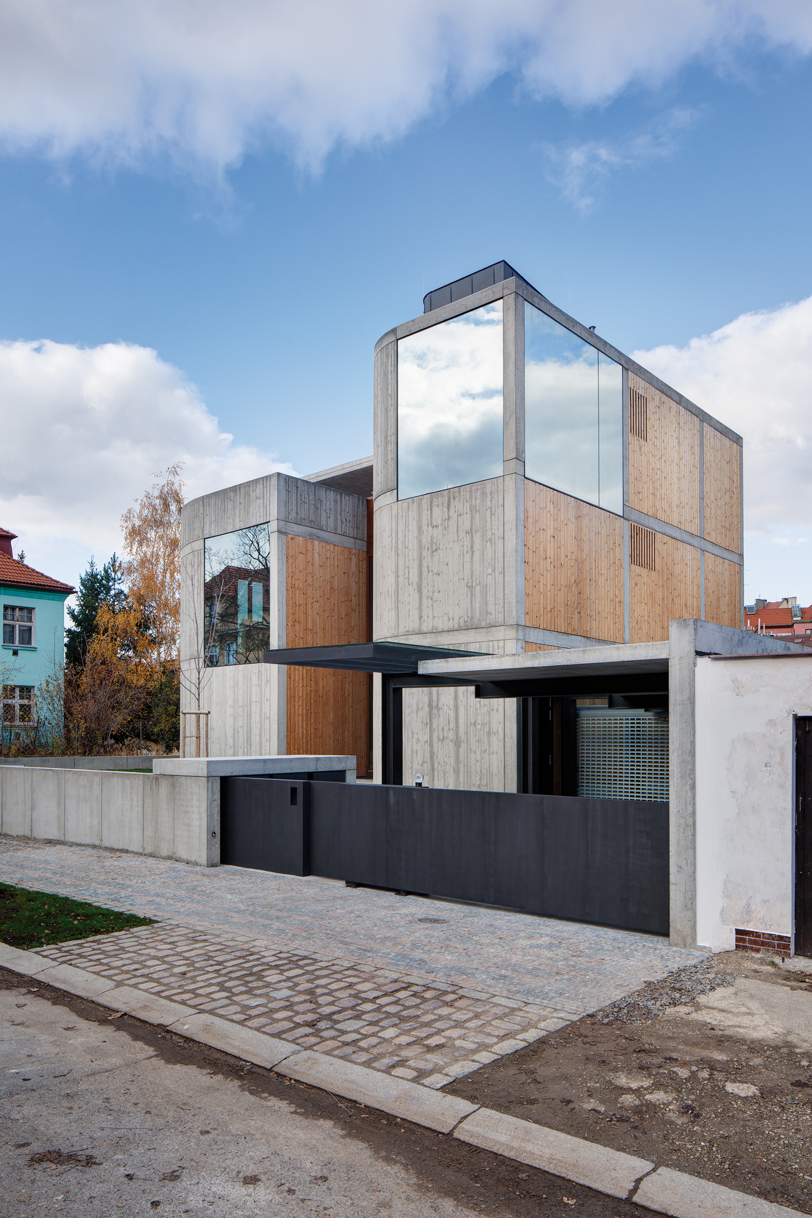 Fasády jsou provedeny z pohledového betonu v kombinaci s dřevěnými obklady.