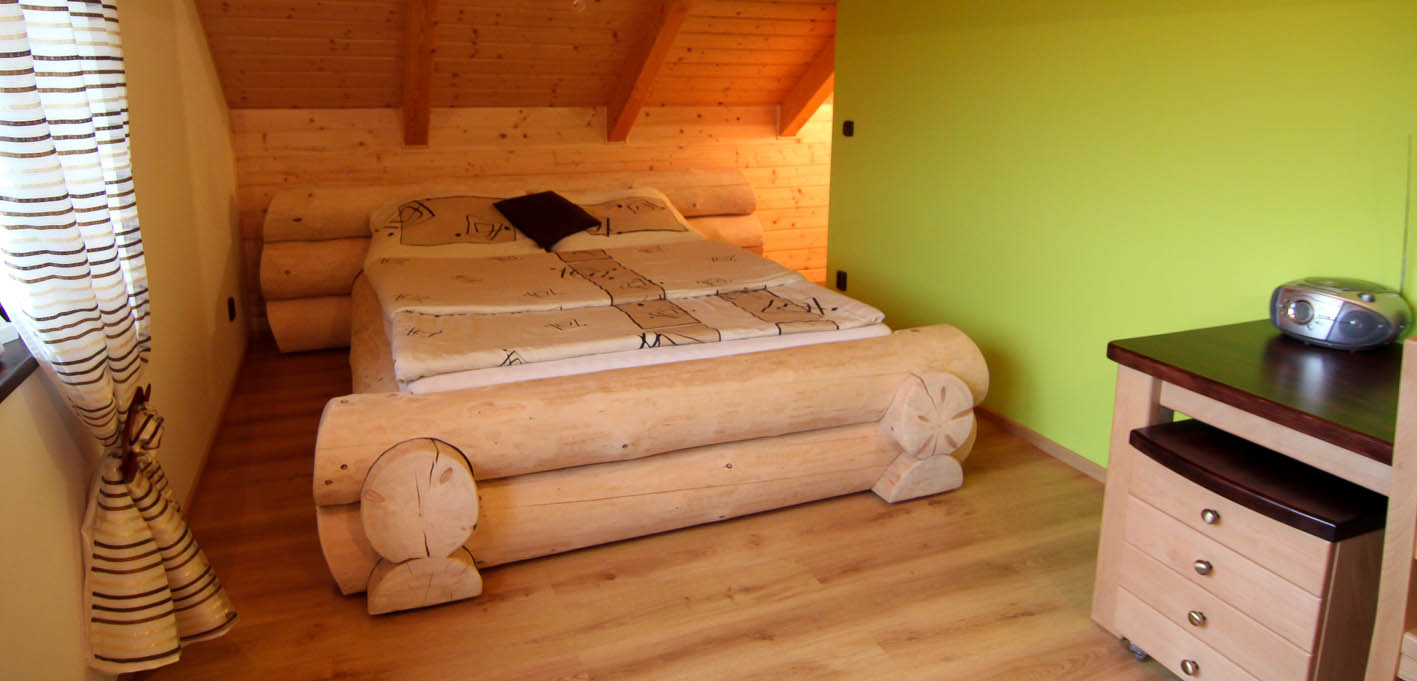 Ložnice je zařízení originální srubovou postelí.